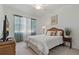 Simple bedroom featuring a white bed, green curtains, and a small side table at 23189 Banbury Way # 203, Venice, FL 34293