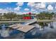 Scenic waterfront area featuring a dock with a bridge, kayaks, and a modern building with a red accent at 23189 Banbury Way # 203, Venice, FL 34293