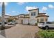 Townhome exterior with attached garages, brick driveways, and tropical landscaping details at 23189 Banbury Way # 203, Venice, FL 34293