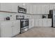 Well-equipped kitchen featuring stainless steel appliances, white cabinetry, and ample countertop space at 23189 Banbury Way # 203, Venice, FL 34293