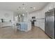 Bright kitchen with white cabinets, a center island with barstool seating, and modern stainless-steel appliances at 23189 Banbury Way # 203, Venice, FL 34293