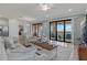 Bright and airy living room with tile floors, comfortable seating, and sliding glass doors to a balcony at 23189 Banbury Way # 203, Venice, FL 34293
