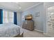 Main bedroom with a large dresser, blue walls, and a view into the attached dining room at 23189 Banbury Way # 203, Venice, FL 34293