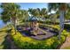 View of the community playground with mature palm trees at 23189 Banbury Way # 203, Venice, FL 34293