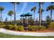 A view of the community playground featuring multiple structures surrounded by palm trees at 23189 Banbury Way # 203, Venice, FL 34293
