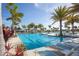 A large swimming pool with lap lanes and shallow areas is surrounded by lounge chairs and palm trees at 23189 Banbury Way # 203, Venice, FL 34293
