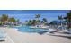 An inviting pool with palm trees and comfortable lounge chairs is perfect for relaxation and recreation at 23189 Banbury Way # 203, Venice, FL 34293