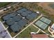 Aerial view of multiple tennis courts with lush landscaping at a new property at 23189 Banbury Way # 203, Venice, FL 34293