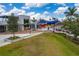 Aerial view of a grassy area with shops and restaurants in a vibrant town center at 23189 Banbury Way # 203, Venice, FL 34293
