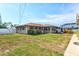 Exterior view of a single-story home showcasing the backyard and screened-in lanai at 2347 Sunnyside Pl, Sarasota, FL 34239