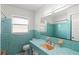 Bathroom with turquoise tile, peach sink, and large mirror, offering a retro and stylish design at 2347 Sunnyside Pl, Sarasota, FL 34239