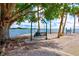 Relaxing bayfront park view featuring a swing under mature trees and scenic water views at 2347 Sunnyside Pl, Sarasota, FL 34239