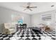 Bedroom with checkerboard floors featuring ceiling fan, desk, bed, and white recliner at 2347 Sunnyside Pl, Sarasota, FL 34239