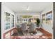Bright dining area featuring terracotta tile floors, a ceiling fan, and floor-to-ceiling windows offering abundant natural light at 2347 Sunnyside Pl, Sarasota, FL 34239