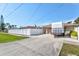 Exterior view of a property featuring a long driveway, garage, and fenced yard at 2347 Sunnyside Pl, Sarasota, FL 34239