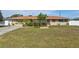 Charming one-story home featuring a well-manicured front yard with lush green grass and mature landscaping at 2347 Sunnyside Pl, Sarasota, FL 34239