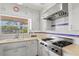 Modern kitchen with white cabinets, stainless steel appliances, and a view of the outdoors from above the sink at 2347 Sunnyside Pl, Sarasota, FL 34239