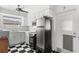 Cozy kitchen featuring white cabinets, stainless steel refrigerator, and classic checkered tile flooring at 2347 Sunnyside Pl, Sarasota, FL 34239
