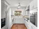 Bright kitchen featuring white cabinets, terracotta tile flooring, stainless steel appliances, and natural light at 2347 Sunnyside Pl, Sarasota, FL 34239