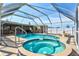 Backyard oasis with a covered pool, spa, and lush landscaping in a screened enclosure at 2347 Sunnyside Pl, Sarasota, FL 34239