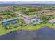 Aerial view of the community amenities, showcasing the pool, tennis courts, and surrounding lakes at 2622 Light Sky Ln, Bradenton, FL 34211