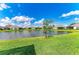 Scenic view of the lake and neighboring homes from the lush backyard at 2622 Light Sky Ln, Bradenton, FL 34211