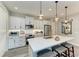 Stylish kitchen with a large island, white cabinets, stainless steel appliances, and modern lighting at 2622 Light Sky Ln, Bradenton, FL 34211