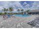 Beautiful outdoor pool with lounge chairs and palm trees, perfect for relaxation and recreation on a sunny day at 2622 Light Sky Ln, Bradenton, FL 34211