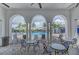 Charming poolside lounge area under an arcade, with tables and chairs for enjoying outdoor relaxation at 2622 Light Sky Ln, Bradenton, FL 34211