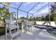 Screened-in pool area with a spa, complemented by patio furniture for relaxation and a view of the lush landscaping at 2655 Oleander Ct, Palm Harbor, FL 34684