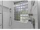 Shower featuring white subway tile, glass block window, and stainless steel hardware at 2655 Oleander Ct, Palm Harbor, FL 34684