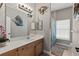 Bathroom featuring a wood vanity, framed mirror, and decorative nautical-themed art at 27350 San Carlos Dr, Punta Gorda, FL 33983