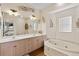 Bright bathroom featuring double sinks, a soaking tub, and decorative wall art at 27350 San Carlos Dr, Punta Gorda, FL 33983