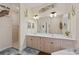 Bathroom featuring double sinks, shower, and decorative nautical-themed art at 27350 San Carlos Dr, Punta Gorda, FL 33983