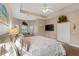 Bright bedroom features a ceiling fan, hardwood floors, and a recessed ceiling at 27350 San Carlos Dr, Punta Gorda, FL 33983