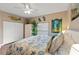 Bedroom with wood floors, ceiling fan, white wardrobe, and seaside themed decor at 27350 San Carlos Dr, Punta Gorda, FL 33983