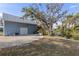 The backyard features an external staircase, pond, and a wooden deck among mature trees and lush foliage at 27350 San Carlos Dr, Punta Gorda, FL 33983