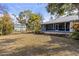 Enjoy outdoor living in this backyard with a spacious lawn, mature trees, lush foliage, and flagstone patio at 27350 San Carlos Dr, Punta Gorda, FL 33983