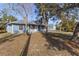 Inviting two-story home with a cozy front porch and mature trees surrounding the property at 27350 San Carlos Dr, Punta Gorda, FL 33983