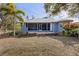 The backyard showcases a screened porch, stone patio and steps, tropical trees, and lush landscaping at 27350 San Carlos Dr, Punta Gorda, FL 33983