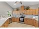 A kitchen features stainless steel appliances, light wood cabinets, neutral countertops and a tile backsplash at 27350 San Carlos Dr, Punta Gorda, FL 33983