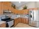 A kitchen with stainless steel appliances, light wood cabinets, neutral countertops and a tile backsplash at 27350 San Carlos Dr, Punta Gorda, FL 33983