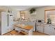 Well-lit kitchen with white appliances, a breakfast island, and natural wood floors at 27350 San Carlos Dr, Punta Gorda, FL 33983