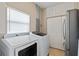 Laundry room featuring modern washer and dryer, storage cabinets, and neutral paint at 27350 San Carlos Dr, Punta Gorda, FL 33983