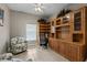 A home office showcases built-in shelving and cabinetry, with a ceiling fan and neutral paint at 27350 San Carlos Dr, Punta Gorda, FL 33983