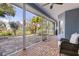 Screened patio with stone floors offers outdoor views of trees and a pond at 27350 San Carlos Dr, Punta Gorda, FL 33983