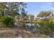 A tranquil pond with a bench provides an idyllic setting on this property; lush trees surround at 27350 San Carlos Dr, Punta Gorda, FL 33983