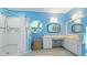 Stylish bathroom with blue walls, tiled shower and vanity area offering bright sunlight at 2760 Siesta Dr, Venice, FL 34293