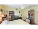 Inviting bedroom with hardwood floors, filled bookshelves, and a reading nook with comfy chair at 2760 Siesta Dr, Venice, FL 34293