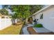 Exterior view highlighting the well-maintained yard and the gravel pathway along the house at 2760 Siesta Dr, Venice, FL 34293